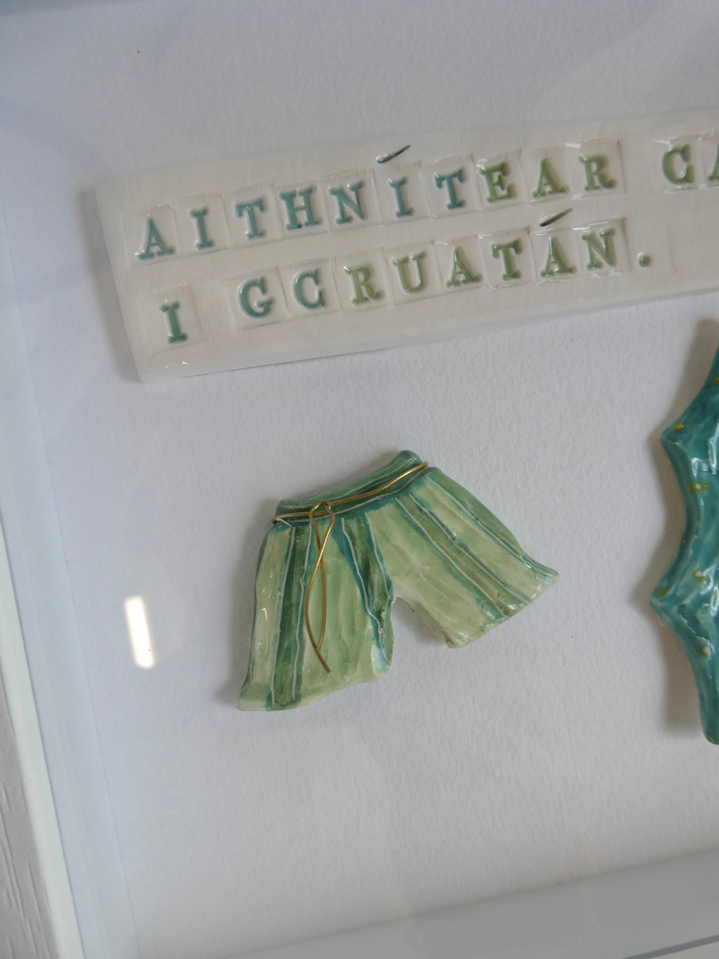 Framed Porcelain - Aithnítear cara i gcruatán.
